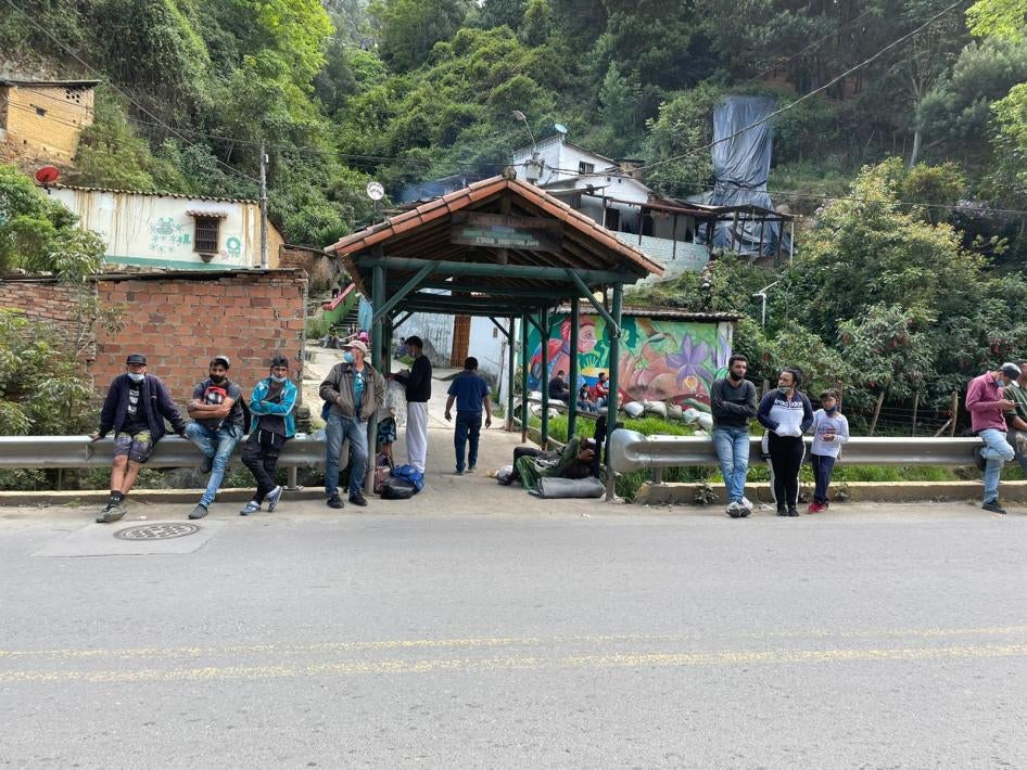 Caminantes venezolanos esperando al costado de una carretera en Colombia, noviembre de 2021.