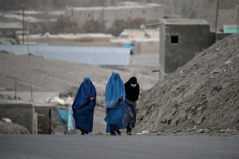 Burqa-clad women walk on a street in Ghazni City, in Ghazni province, Afghanistan.