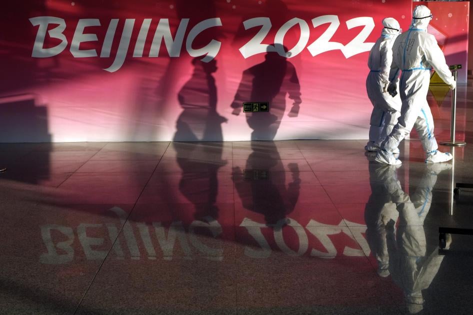 Olympic workers in protective gear walk through the Beijing Capital International Airport to assist passengers ahead of the 2022 Winter Olympics, in Beijing, January 31, 2022. 