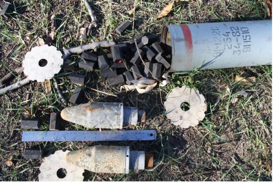 Fragments d'une roquette incendiaire russe Grad 9M22S de 122 mm, retrouvés en 2014 près d'Ilovaïsk, dans l’est de l’Ukraine. Chaque roquette contient 180 capsules hexagonales noires en alliage de magnésium ML-5, contenant un composé pyrotechnique qui brûle pendant environ deux minutes à haute température.