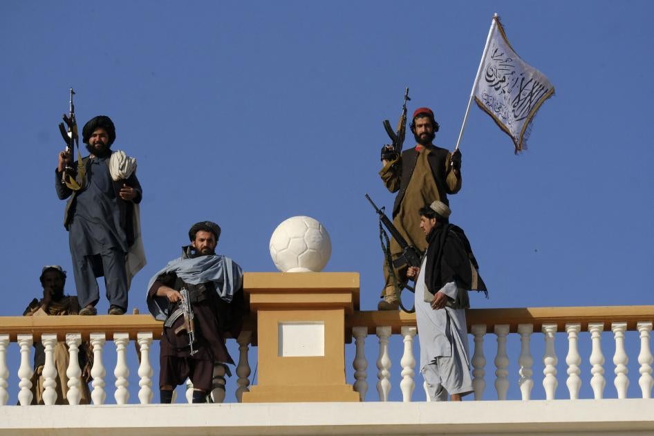 Armed men stand atop a city gate