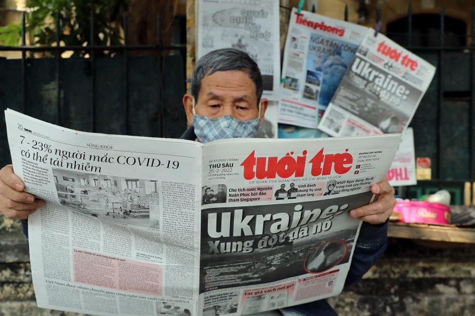 Một người đàn ông đọc báo tiếng Việt trên trang nhất có bài viết về Nga xâm lược Ukraine tại một quầy báo ở Hà Nội, ngày 25 tháng Hai năm 2022.