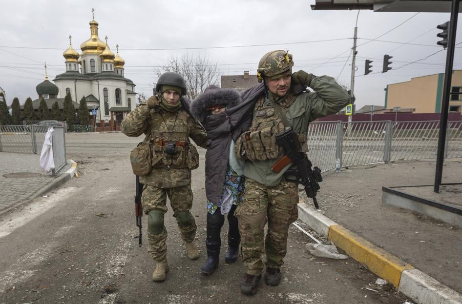 Украинские солдаты оказывают помощь женщине в городе Ирпень, 6 марта, Украина.