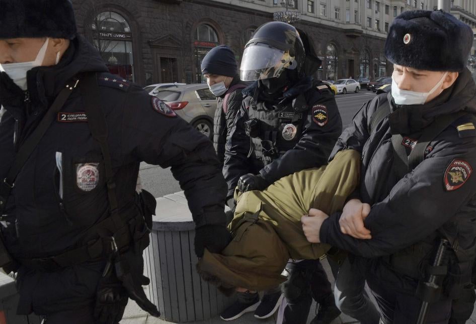 Ces trois policiers russes emmenaient de force un manifestant, courbé vers l’avant, qui participait à un rassemblement sur la Place du Manège (place Manezhnaya) à Moscou, le 6 mars 2022. 