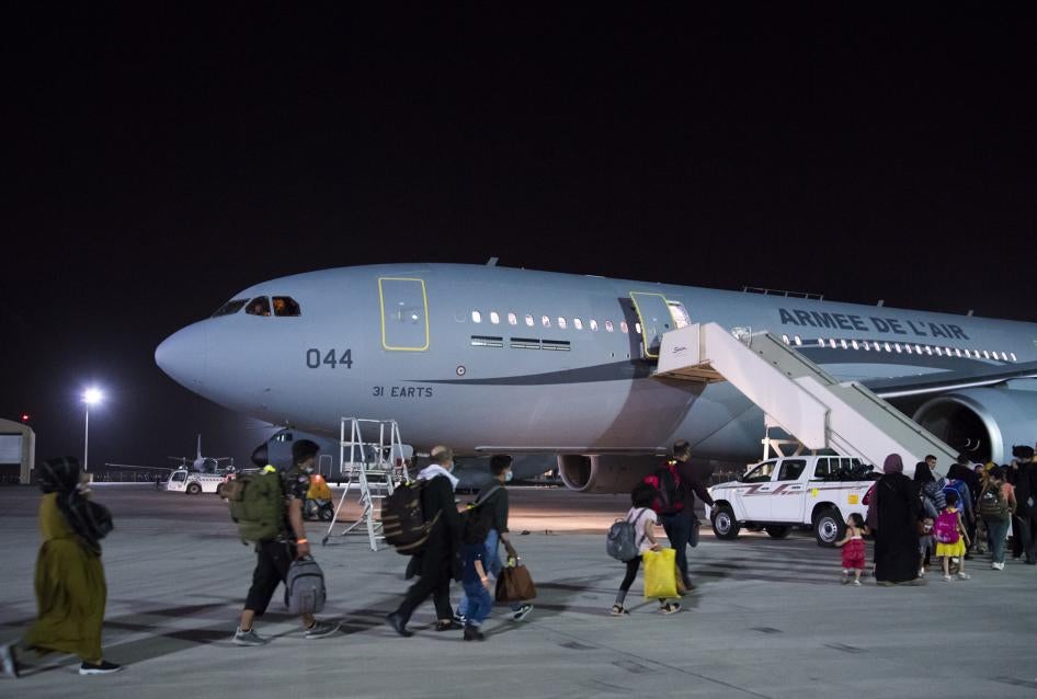 Des citoyens français et afghans sont évacués vers la France dans un avion militaire français, à l'aéroport d'Abu Dhabi, le 24 août 2021
