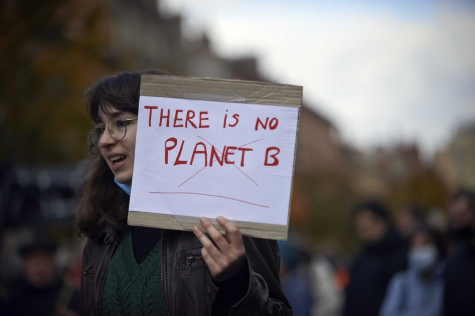 A young woman holds a placard that reads “There is no Planet B” at a climate change rally in Toulouse