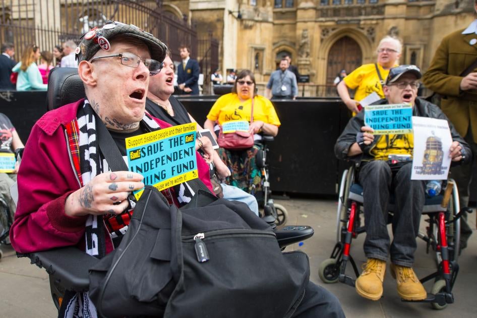Protesters in wheelchairs hold signs