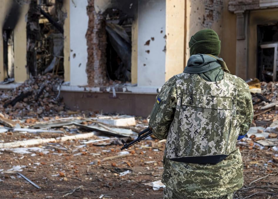 Un soldat ukrainien, face aux décombres de l'École spécialisée 134 à Kharkiv, en Ukraine, le 17 mars 2022. Cette école a pris feu après avoir été bombardée par les forces russes.