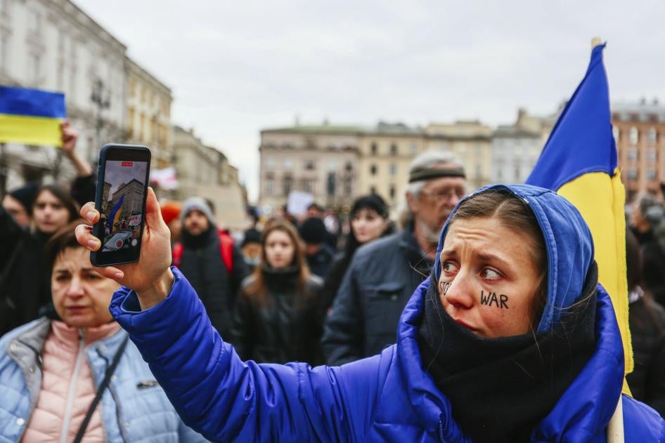 Протестующая ведет прямую видеотрансляцию демонстрации с смартфона в Кракове, Польша, 27 февраля 2022 года. 