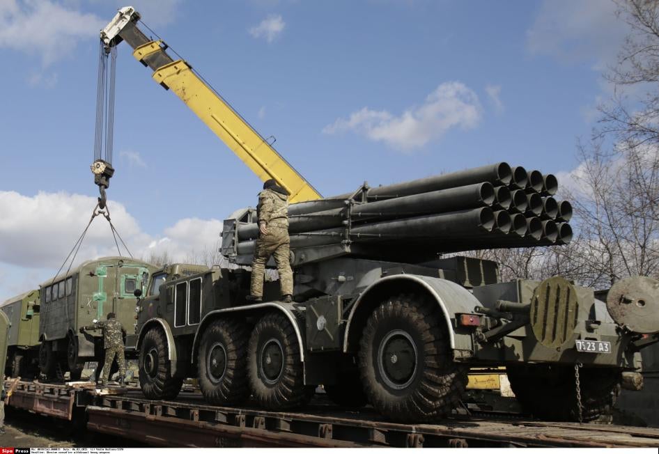 Des soldats ukrainiens chargeaient un système de lance-roquettes multiple Uragan sur un train de marchandises à la gare d'Artemivsk, dans l'est de l'Ukraine, le 6 mars 2015. La batterie de 16 tubes peut être utilisée pour tirer des roquettes à sous-munitions. 