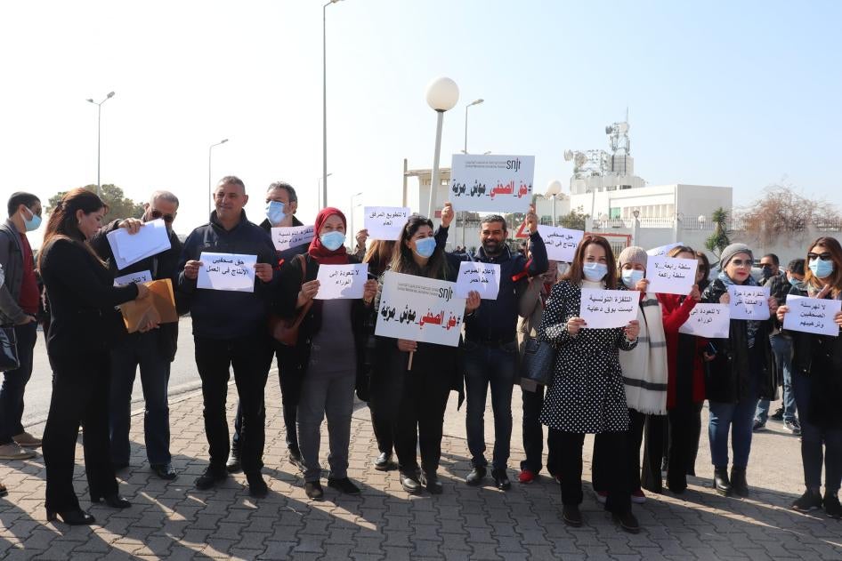 أعضاء من "النقابة الوطنية للصحفيين التونسيين" يحتجون أمام مقر التلفزيون الحكومي، 11 مارس/آذار 2022. 