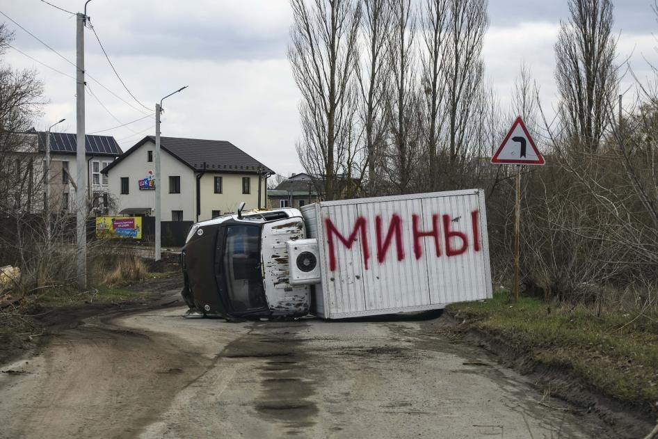 Un véhicule partiellement détruit et renversé à Boutcha, en Ukraine. Le mot "mines" en russe (мины) a été inscrit en énormes lettres rouges sur le haut du véhicule renversé. Photo prise le 4 avril 2022.