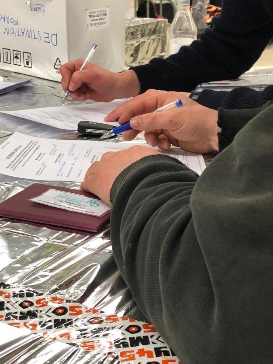 Kierowcy oferujący prywatny transport uchodźcom wypełniają formularze w systemie rejestracji opracowanym i prowadzonym przez wolontariuszy w ośrodku recepcyjnym w Korczowej, Polska, 22 marca 2022 r. 