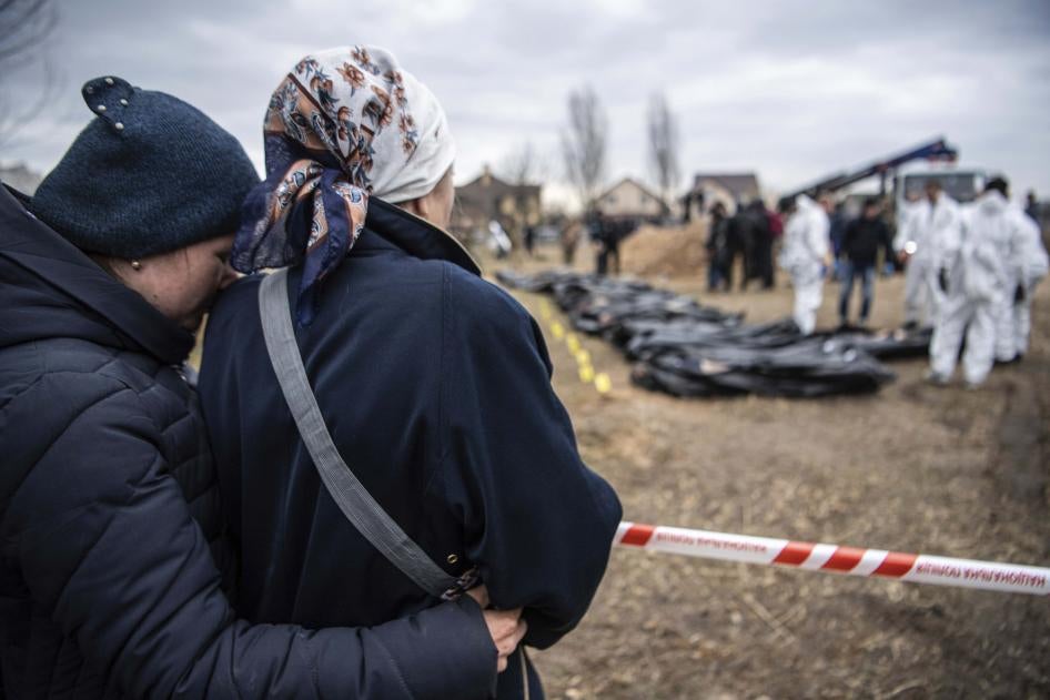 Deux femmes assistaient de loin à l’exhumation de corps qui avaient été enterrés par les forces russes dans une fosse commune à Boutcha, en Ukraine. Cette exhumation était supervisée par les autorités ukrainiennes dans le cadre de leurs enquêtes sur des crimes de guerre perpétrés dans cette ville.