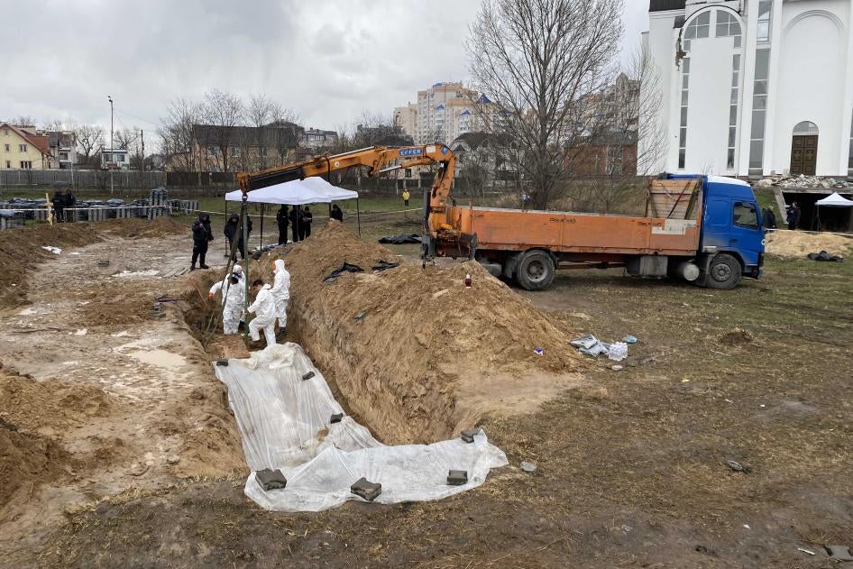 Exhumation de corps de victimes qui avaient été provisoirement enterrées dans une fosse commune derrière l'église Saint-André et Pyervozvannoho Toussaint à Boutcha, en Ukraine, pendant l'occupation de la ville par les forces russes en mars 2022.