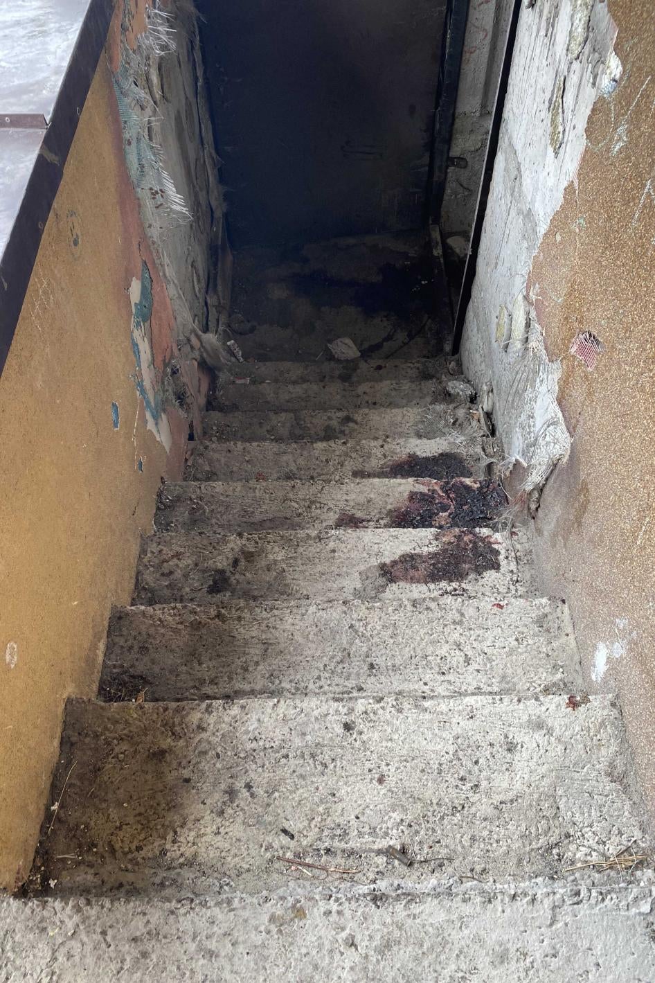Two large blood stains on a stairwell where bodies of two men in civilian clothes were found