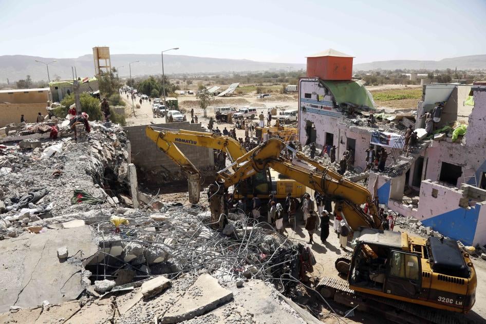 People inspecting a demolished Houthi-controlled detention facility.