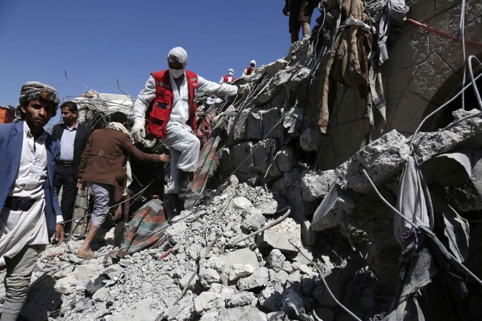 Des secouristes parmi les décombres d’un centre de détention géré par les forces houthies dans le gouvernorat de Saada, au Yémen, suite à une frappe aérienne menée par la coalition dirigée par l'Arabie saoudite et les Émirats arabes unis, le 22 janvier 2022. 