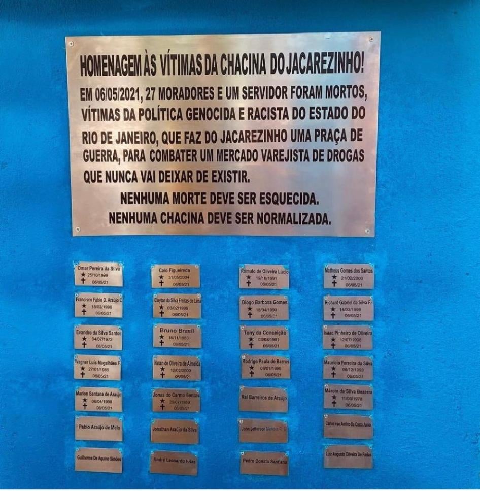 The memorial in the Jacarezinho neighborhood in Rio de Janeiro, Brazil showing an inscription and names of those killed on metal plates