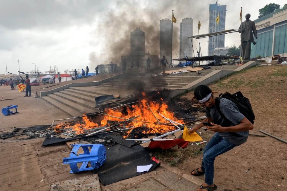 A Sri Lankan anti-government protester tries to save some papers from a tent that was set on fire