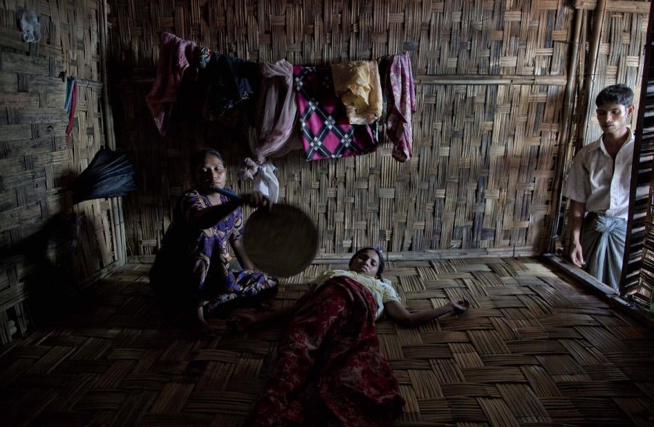 A Rohingya woman is fanned by a relative 