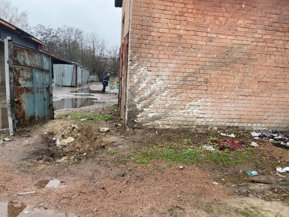  À gauche sur la photo, l’on voit un cratère d'impact de munition, suite à une attaque russe du 16 mars 2022 qui a tué 17 personnes et en a blessé 25 autres alors qu'elles attendaient une distribution de pain dans la rue Dotsenka à Tchernihiv. Photo prise le 19 avril 2022.