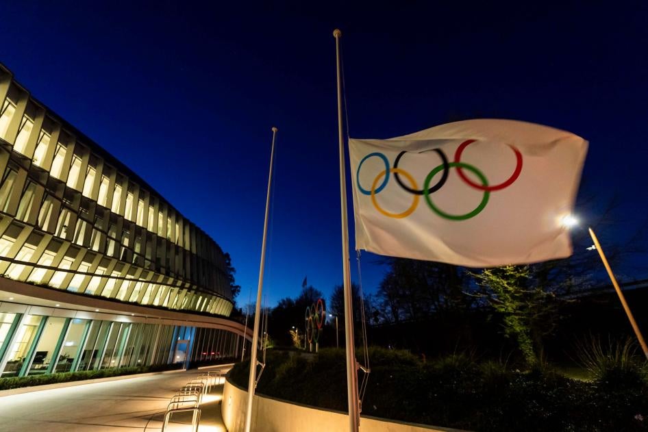 Un drapeau olympique, montrant les cinq anneaux des JO sur fond blanc, flottait devant l'entrée du siège du Comité international olympique (CIO) à Lausanne, en Suisse, le 23 mars 2020. 