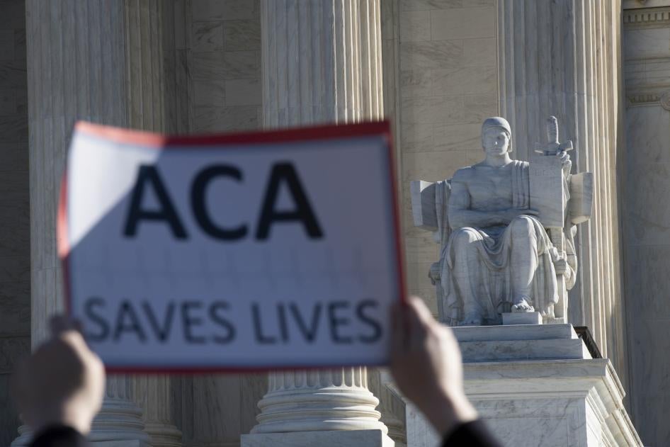 A protester holds up a sign that says "ACA saves lives"