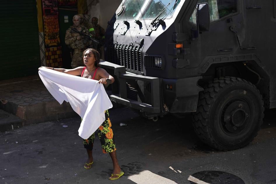 Uma moradora acena com lençol branco pedindo paz após uma operação policial que resultou em várias mortes, no Complexo do Alemão, no Rio de Janeiro, Brasil, 21 de julho de 2022. 