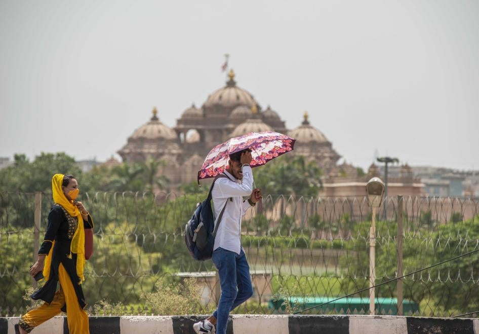 Un homme tenait un parapluie afin de maintenir son visage dans l’ombre, lors d'une vague de chaleur à New Delhi, en Inde, le 12 juin 2022.
