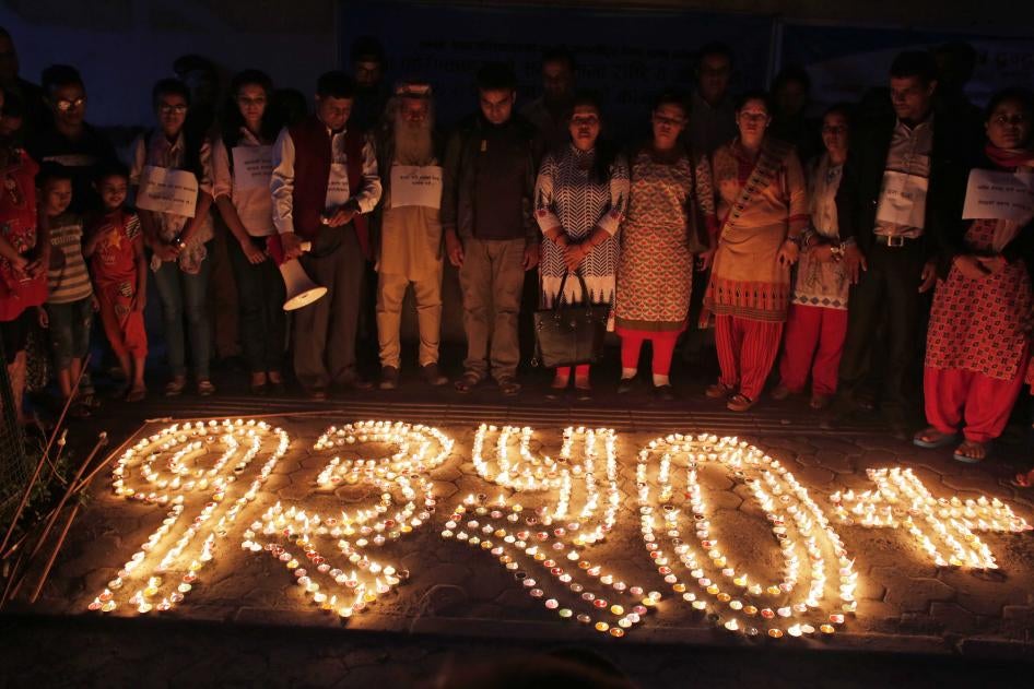 Nepalese human rights activists and relatives of disappeared persons, make a formation with lighted candles that reads 1350+ (referring to the number of victims) at an event to mark the International Day of the Disappeared in Kathmandu, Nepal, August 30, 2017.