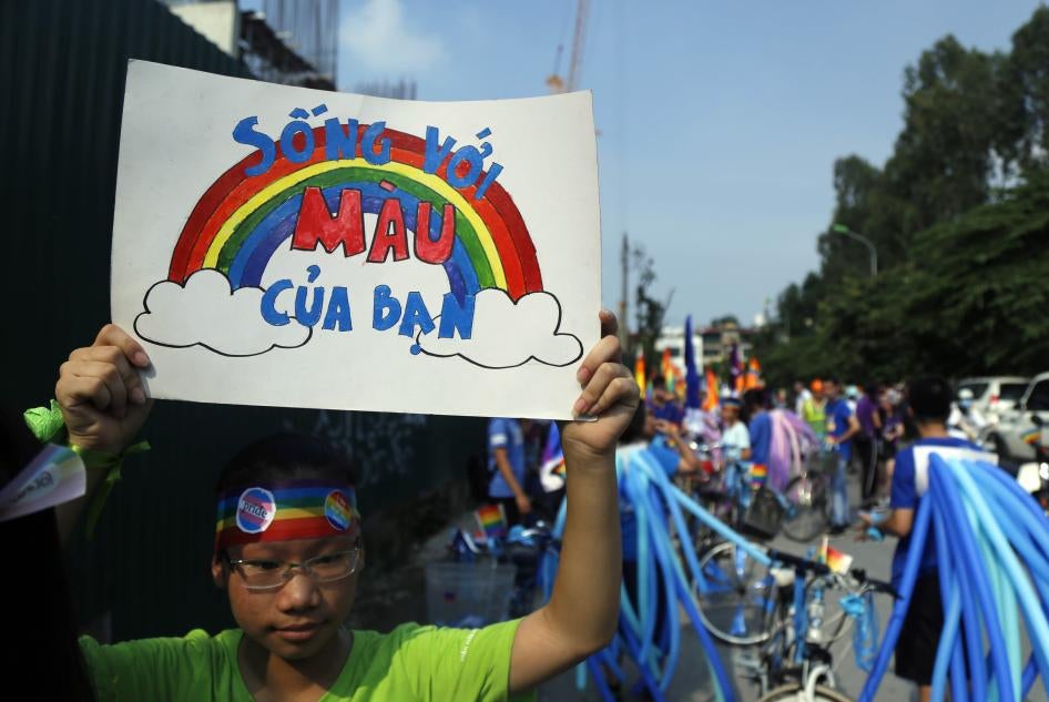 A cyclist holds up a poster reading in Vietnamese, "Shine your true colors," ahead of a bike rally in Hanoi, Vietnam, September 24, 2017. 