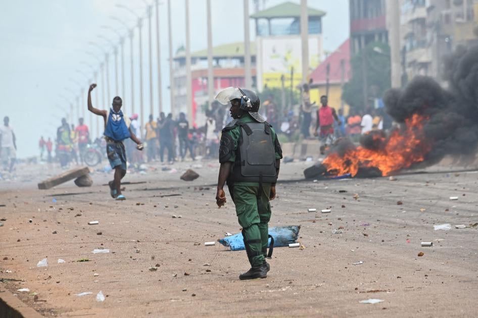 Un policier regarde des partisans de la coalition d'opposition, le Front national pour la défense de la Constitution (FNDC), bloquer des routes après que les autorités leur ont interdit de manifester à Conakry, en Guinée, le 28 juillet 2022.