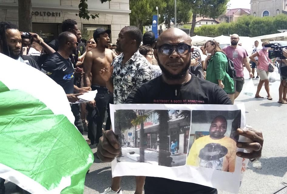 Un uomo mostra la foto della vittima Alika Ogorchukwu, venditore ambulante nigeriano, a Civitanova Marche, Italia, 30 luglio 2022.