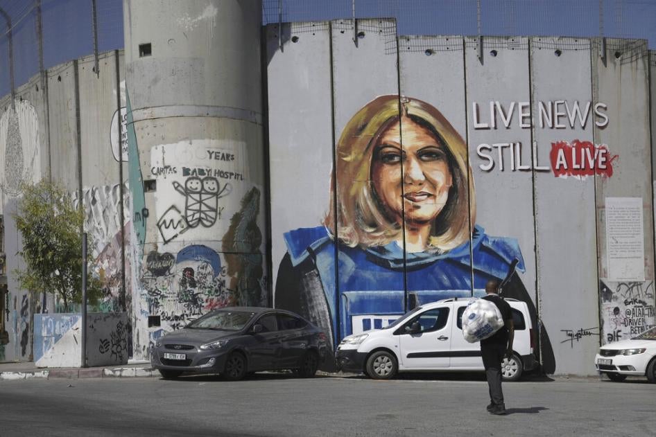 A man walks near a mural depicting slain Palestinian American journalist Shireen Abu Akleh, on Israel's controversial separation barrier in the West Bank city of Bethlehem