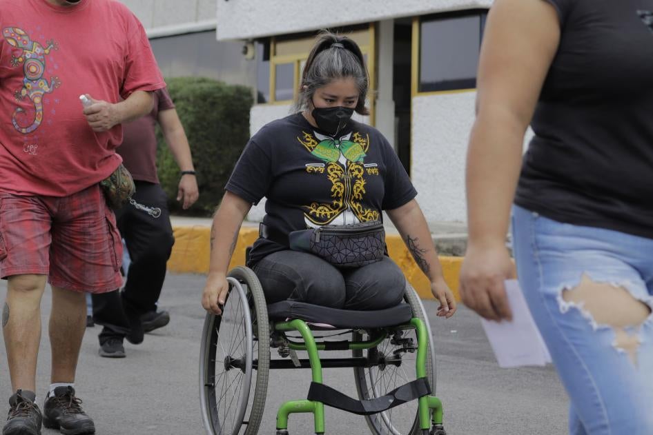 A woman with a disability moves in her wheelchair in a street in Iztapalapa, Mexico City, in June 2021.