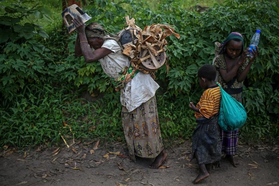 Une femme autochtone et ses enfants se rendent sur un marché pour vendre des poteries sur l'île d'Idjwi.