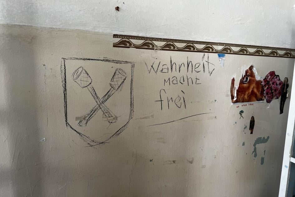 Las palabras en alemán “La verdad te hace libre” escritas en la pared de una de las salas de la Policlínica de Ferrocarriles de la Ciudad, y un emblema que podría representar granadas de palo cruzadas, que era el símbolo de una brigada alemana de las SS de la Segunda Guerra Mundial, la Brigada Dirlewanger, en Izium, Ucrania, 22 de septiembre de 2022.