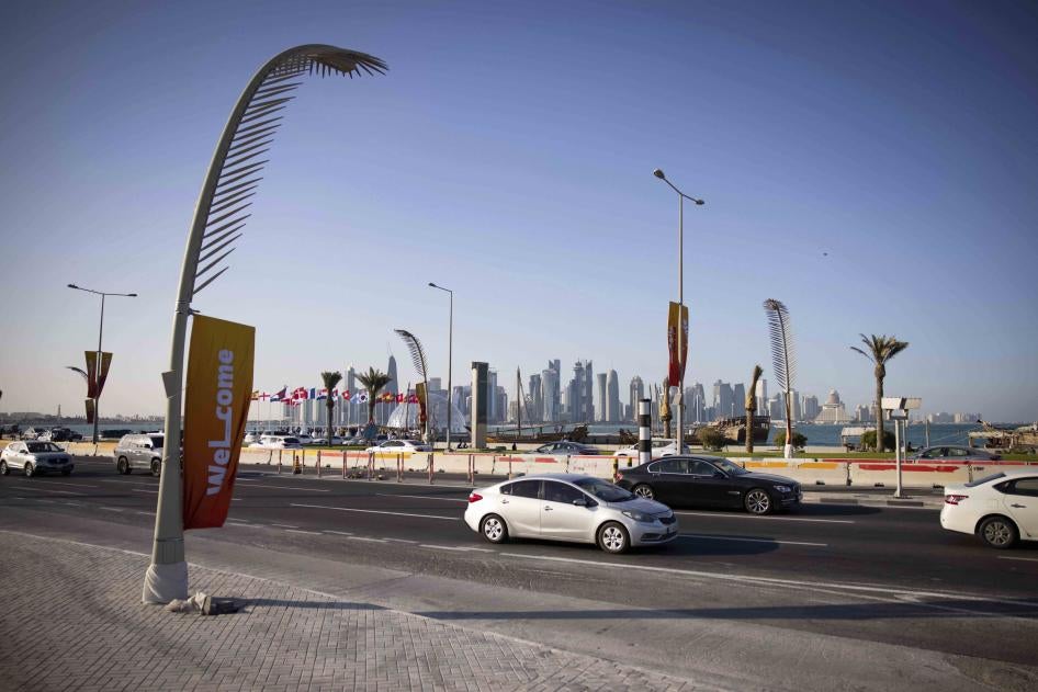 Des voitures passent devant la Corniche de Doha, au Qatar, avec les tours du quartier de West Bay visibles en arrière-plan.   