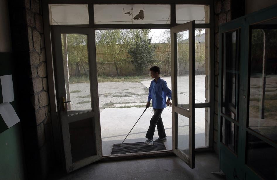 A student with a white cane arrives at a school in Kabul, Afghanistan.