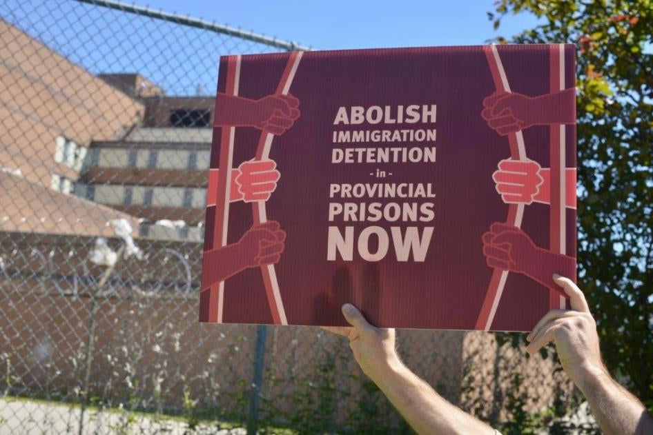 Un manifestant tenait une pancarte devant une prison provinciale à Toronto lors d'un rassemblement contre la détention des migrants, en 2022. 