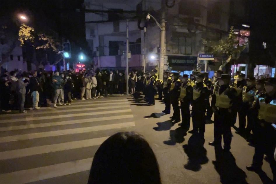 Des policiers chinois déployés devant un groupe de personnes qui s'étaient rassemblées à Shanghai le 27 novembre 2022, entravant ainsi leur tentative de manifester contre la politique draconienne « zéro Covid ».