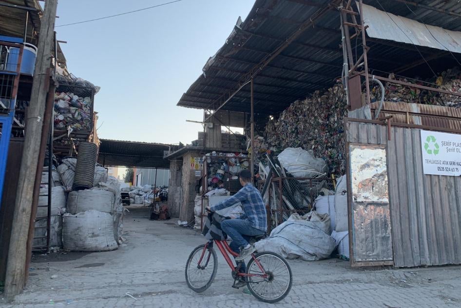 A boy sits on a bicycle in front of a plastic recycling facility in Adana, Turkey.