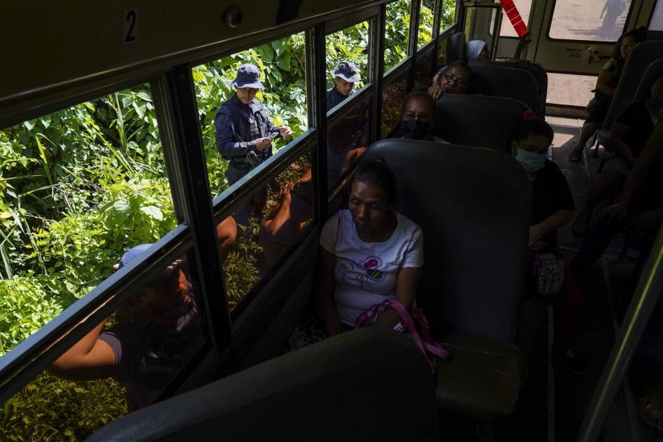 Des policiers salvadoriens contrôlaient les papiers d’identité de deux hommes qu’ils ont fait sortir d’un bus, lors d'une opération visant à identifier et arrêter des membres de gangs à Santa Ana, au Salvador, le 30 juin 2022.