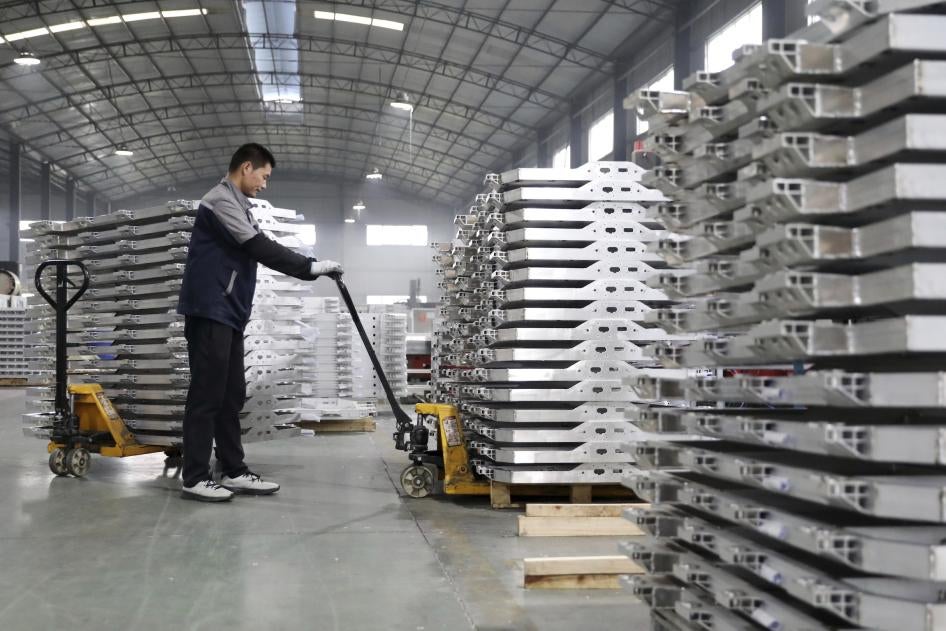 中国安徽省一家汽车制造厂，员工正在搬运铝制零件，2022年3月26日。