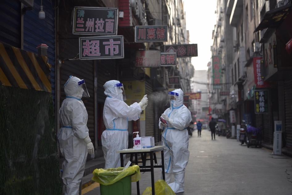 A medical worker disinfects her colleague's protective shield at a residential community under closed-off management in Xi'an, China.