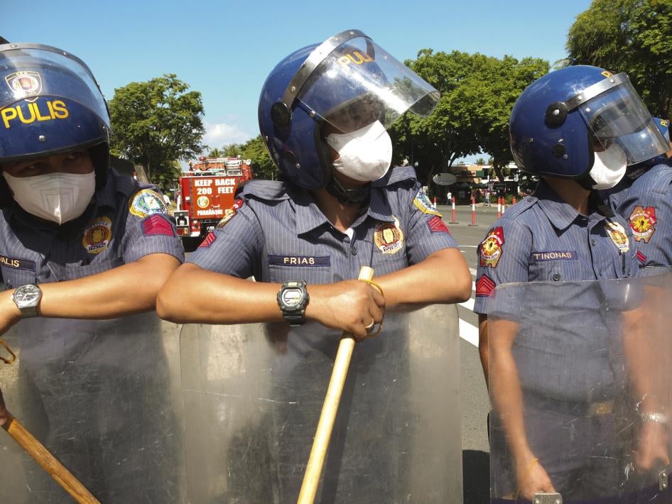 Philippine police officers with batons during a demonstration by youth group activists in Manilla,