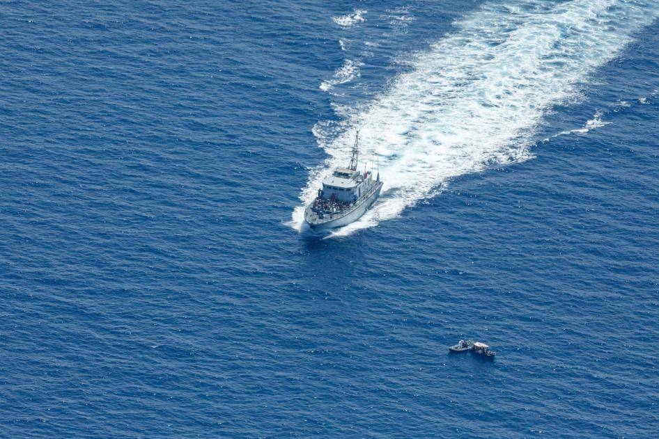 Le navire de patrouille libyen Ras Jadir, à gauche, interceptait une embarcation transportant des migrants en mer Méditerranée, le 30 juillet 2021. 