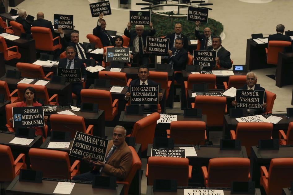 أعضاء معارضون في البرلمان يحملون لافتات تحتج على قانون اقترحته حكومة إردوغان لتجريم المعلومات الزائفة وتشديد السيطرة على وسائل التواصل الاجتماعي كمحاولة لزيادة الرقابة تمهيدا لانتخابات 2023. 11 أكتوبر/تشرين الأول 2022. 