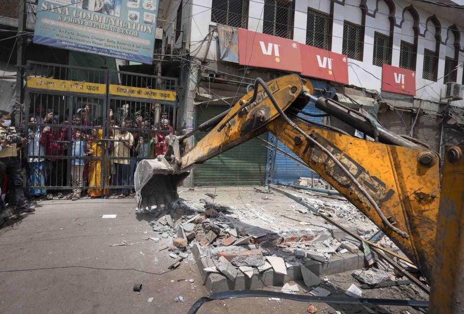 A bulldozer razes structures in an area affected by communal violence during a Hindu religious procession in New Delhi's Jahangirpuri neighborhood, April 20, 2022.
